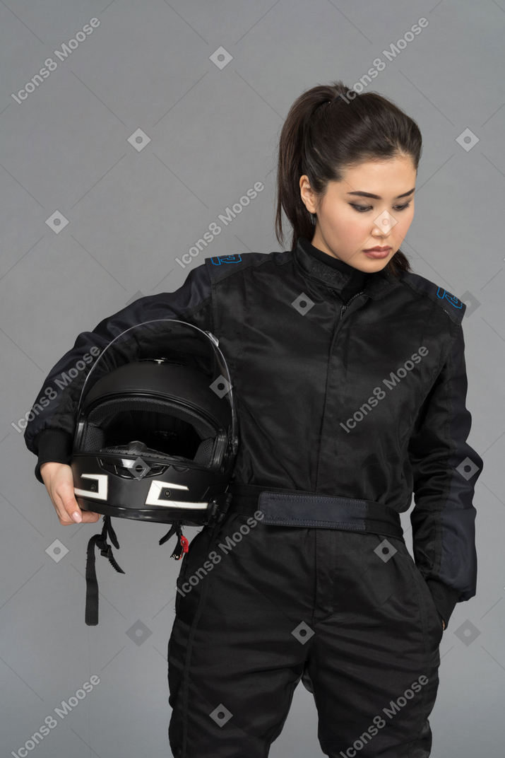 Uma jovem pensativa segurando um capacete