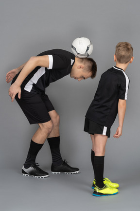 De cuerpo entero de un joven entrenando a un niño