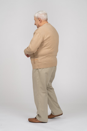 Vue latérale d'un vieil homme en vêtements décontractés marchant