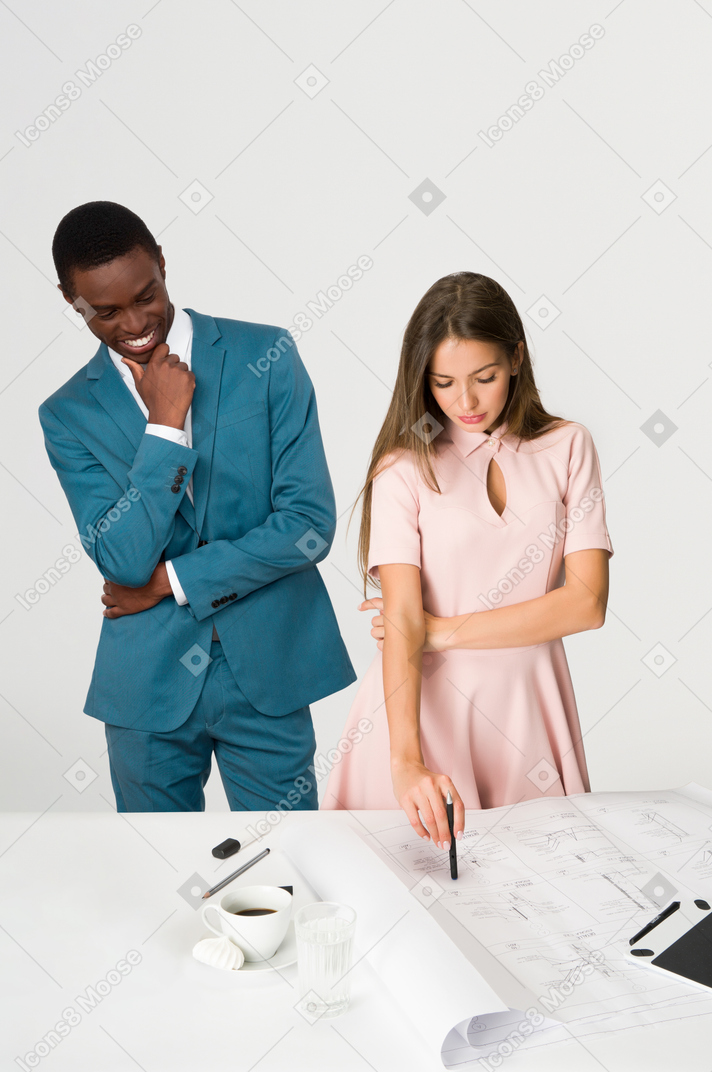 Female worker standing at the table and male colleague checking out her butt