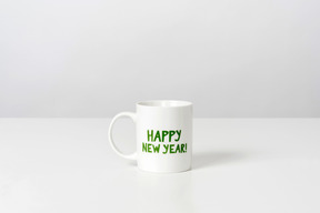 Taza blanca con feliz año nuevo signo en él