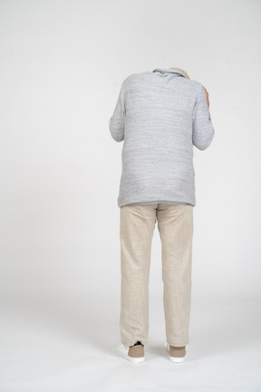 Back view of a man standing and tilting his head