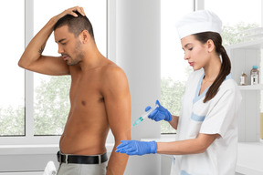 Nurse injecting man's arm