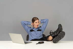 Um guarda de segurança feminino sonolento bocejando em sua mesa