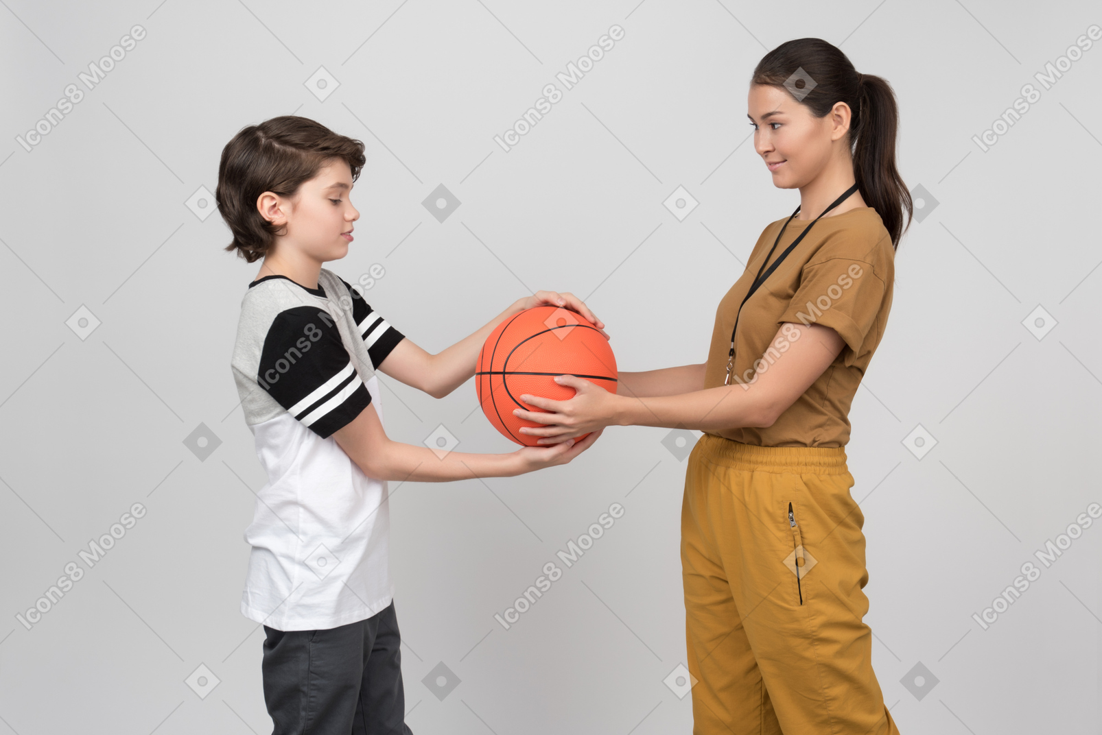Pe女教師と生徒がバスケットボールを保持