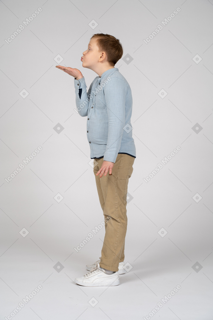 Side view of a cute boy blowing a kiss