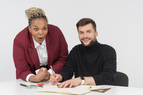 Surprised colleagues looking sideways in amusement