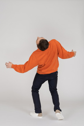 Junger mann im orange sweatshirt springen