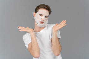 Front view of a young man posing in facial mask