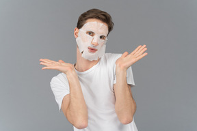 Vue de face d'un jeune homme posant dans un masque facial