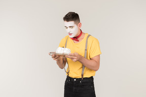 Male clown holding a white cake