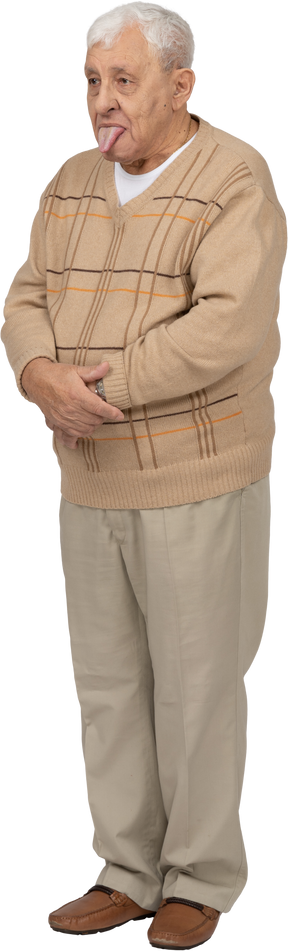 Vista frontale di un uomo anziano in abiti casual che mostra la lingua