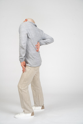 Vista laterale di un uomo di mezza età che soffre di mal di schiena