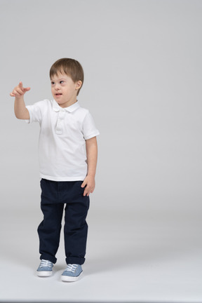 Front view of little boy pointing his finger at camera