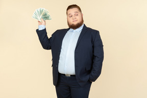 A plus-size man in a black costume with dollar bills in his hands