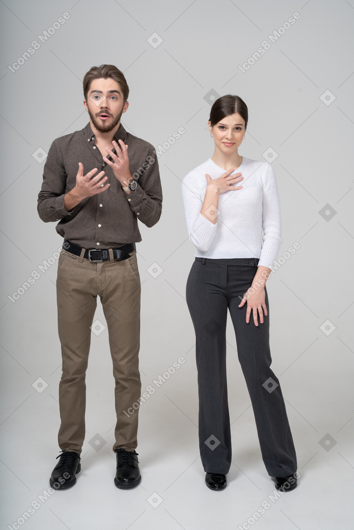 Vista frontal de un joven interrogante y una mujer complacida en ropa de oficina