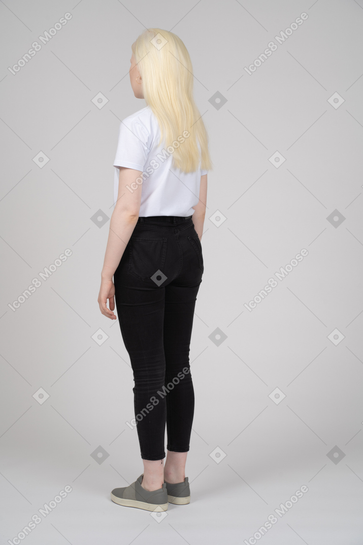 Vista posteriore di tre quarti di una ragazza adolescente in abiti casual