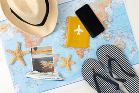 Striped flip-flops, straw hat, an international passport, smartphone and some souvenirs from the latest journey all brought together to create that summer vacation vibe you can feel already