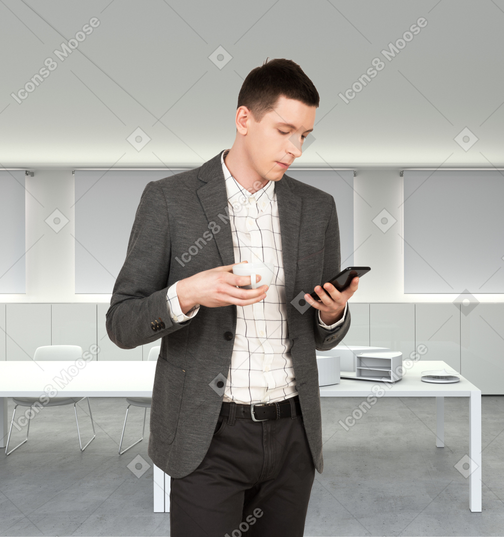 A man standing in a room looking at his cell phone