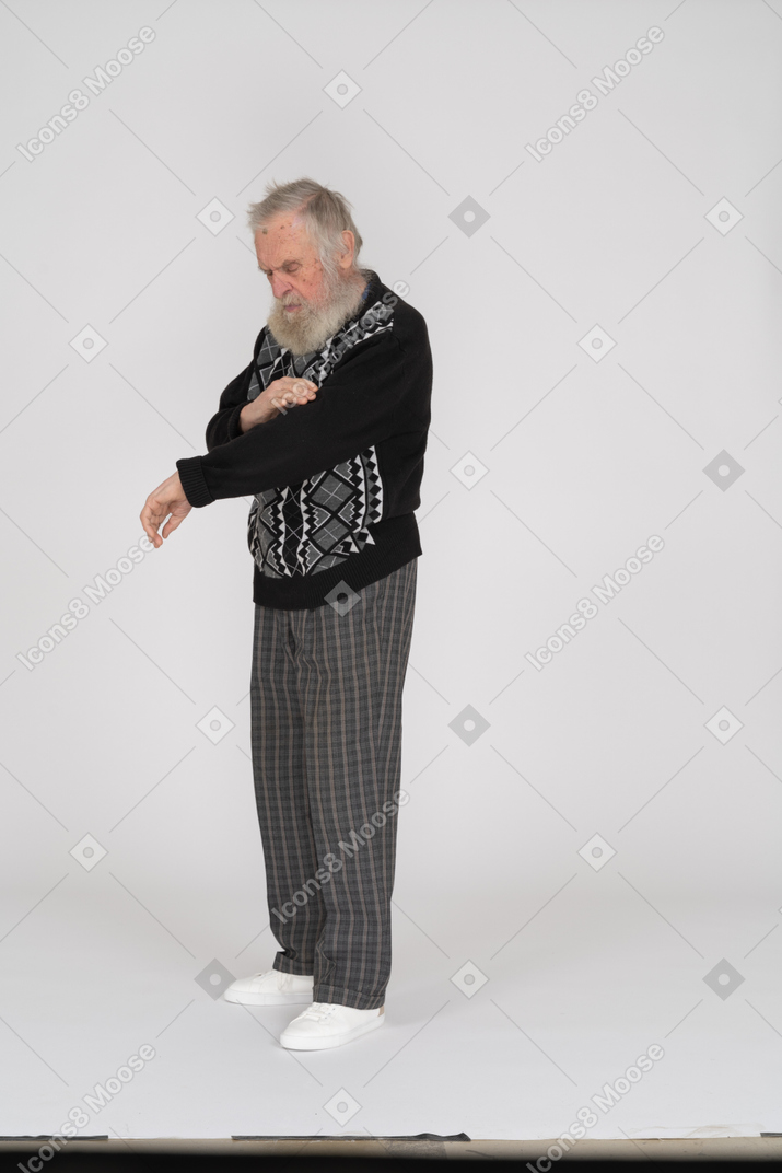 Senior man removing lint from his sweater