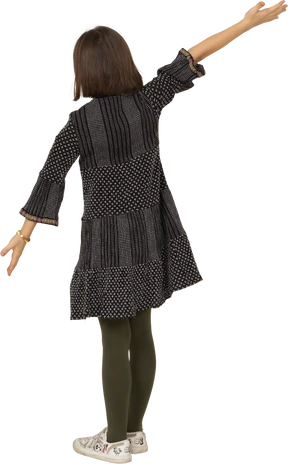Three-quarter back view of a little girl in dress outspreading her arms