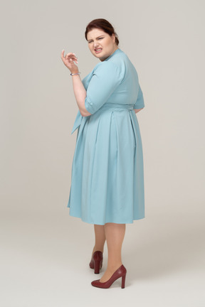 一个穿蓝色裙子的女人做鬼脸的侧视图