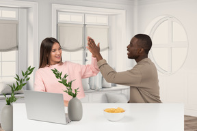 A man and woman sitting at a table with laptop