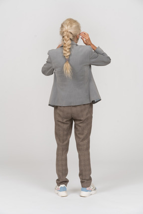 Back view of an old lady in suit