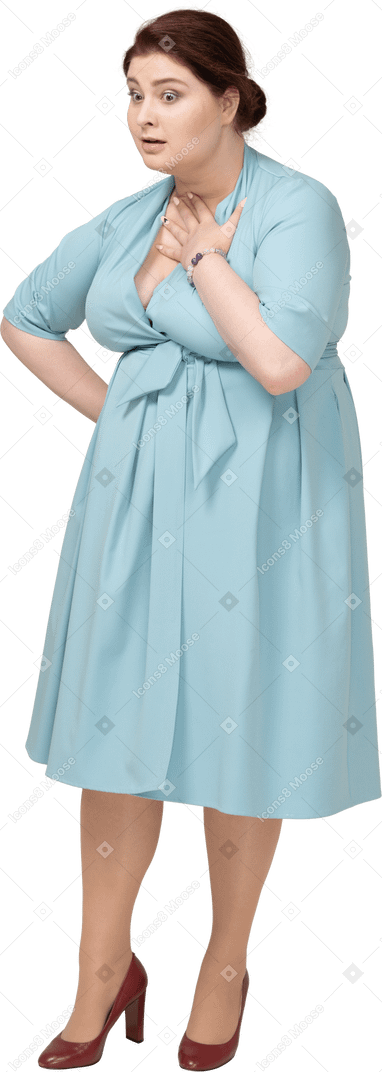 一位身穿蓝色连衣裙、抚摸脖子的震惊女人的前视图