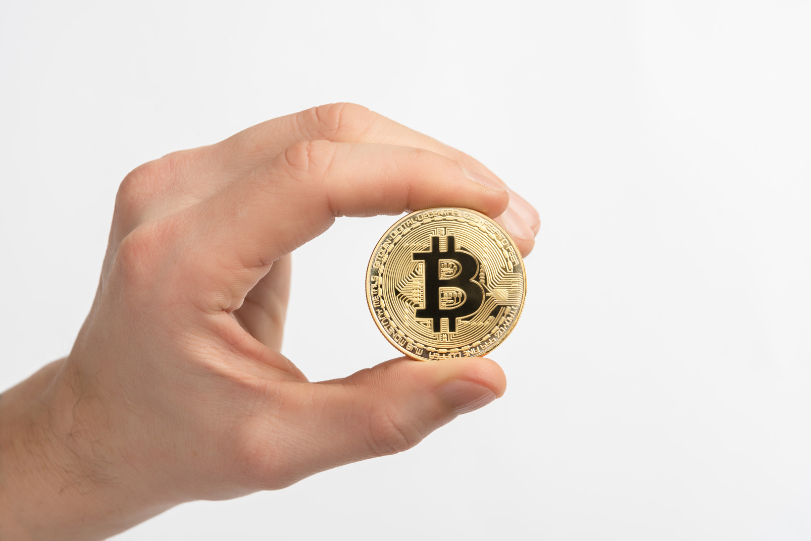 Male hand holding golden bitcoin