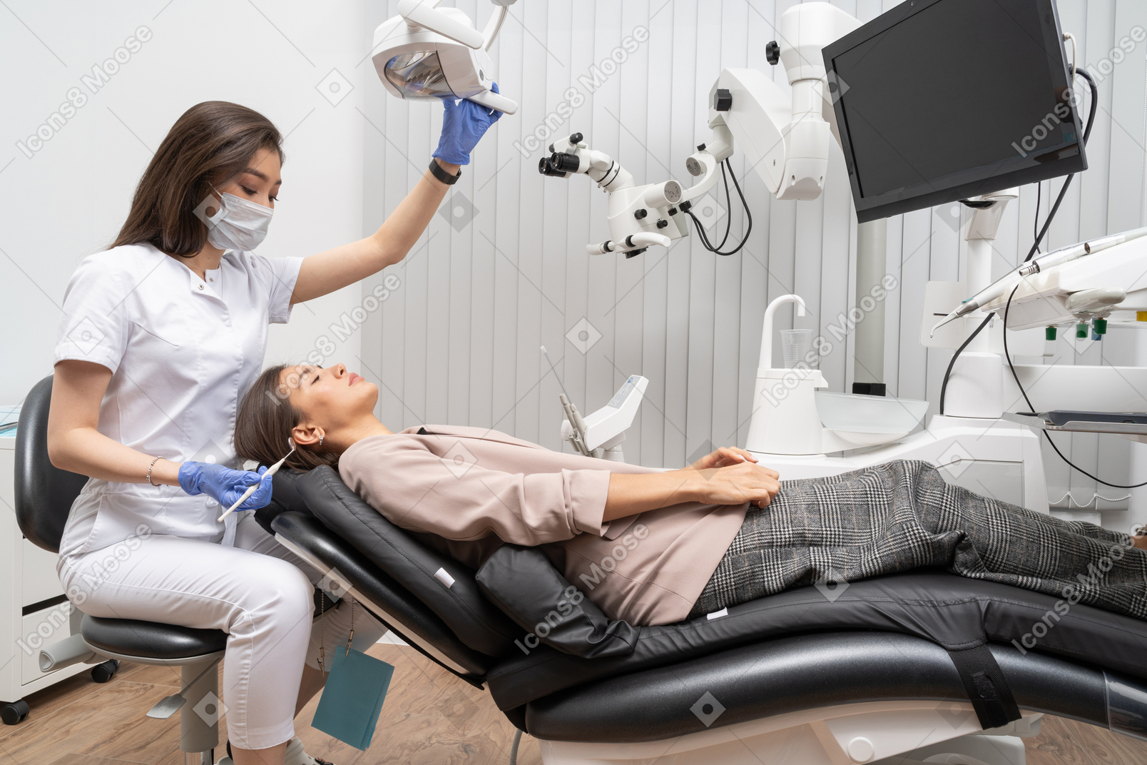 Женщина-стоматолог в полный рост осматривает свою пациентку, лежащую в больничном шкафу