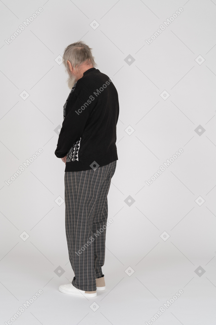 Back view of old man standing and looking down