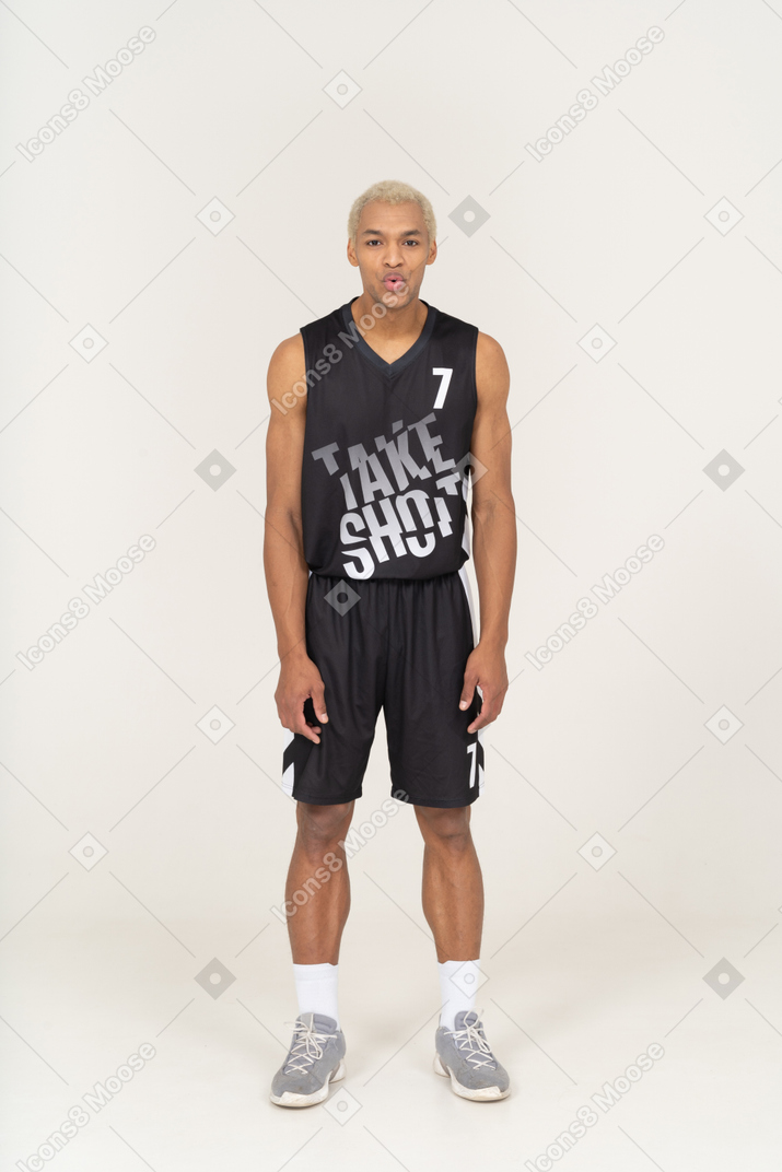 Vista frontal de um jovem jogador de basquete masculino assobiando, inclinando-se para a frente