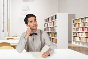 A man sitting at a table with a book in front of him