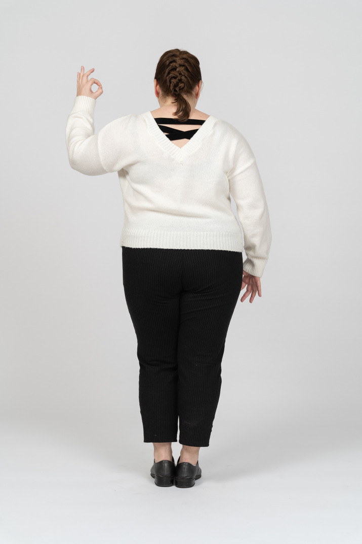 Plump woman in casual clothes showing ok sign