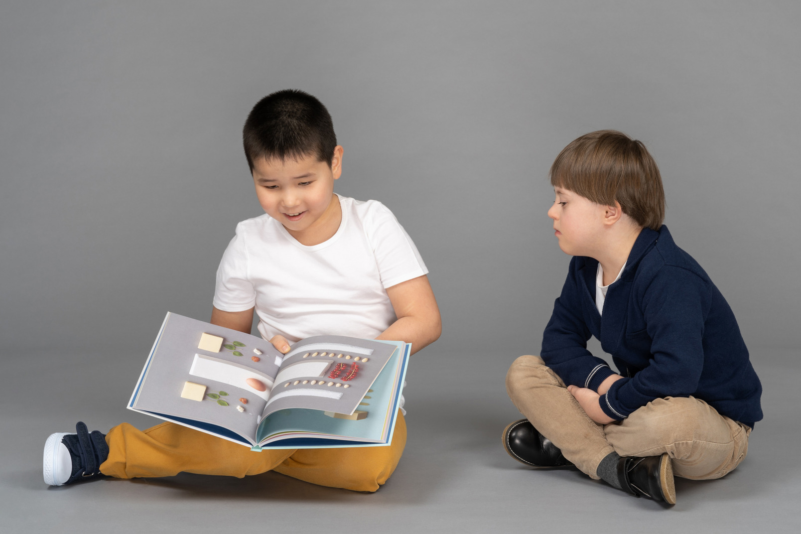 Two little friends reading book together