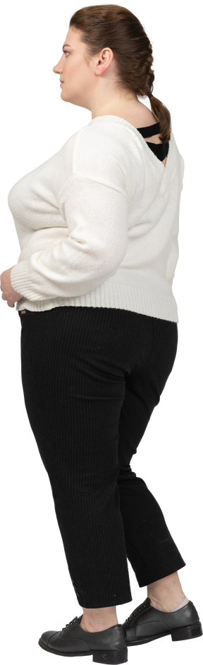 Plump woman in white sweater posing with hands on hips