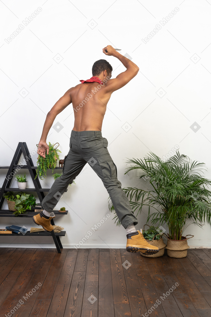 Athletic man jumping up with a knife in his hand