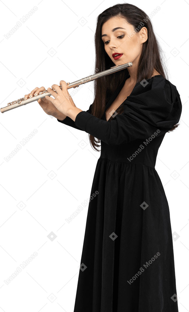 フルートを演奏する黒いドレスを着た真面目な若い女性の4分の3のビュー