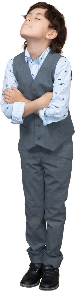 Front view of a boy in suit posing with crossed arms