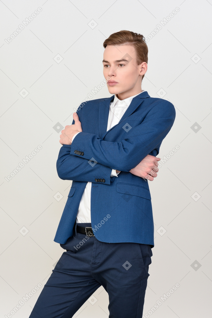 Handsome young man standing with his hands crossed