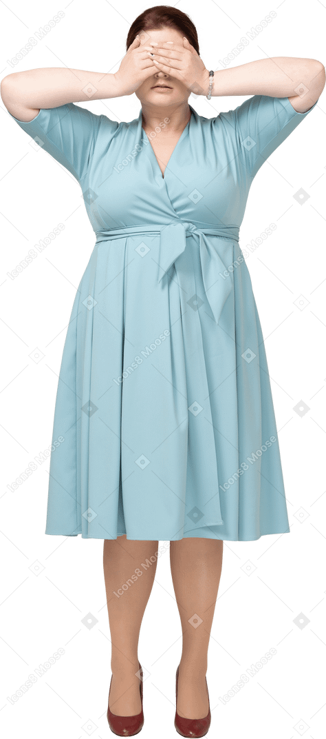 Vista frontal de una mujer en vestido azul que cubre los ojos con las manos
