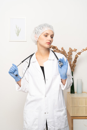 Vista frontal de una joven doctora sosteniendo estetoscopio