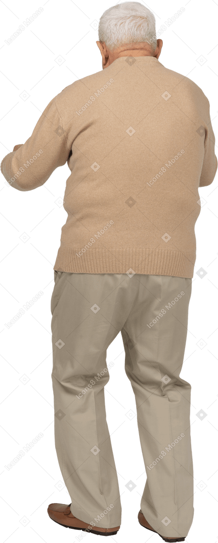 Vista trasera de un anciano con ropa informal de pie con los puños apretados