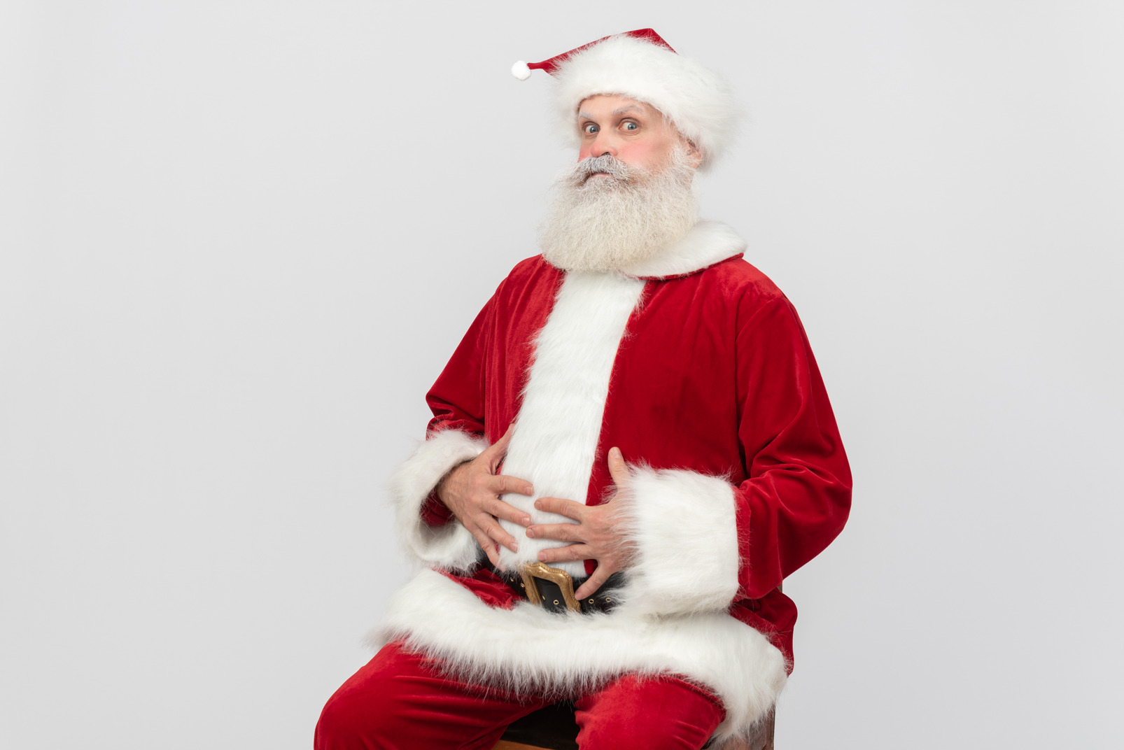 Santa claus sitting with hands on his stomach