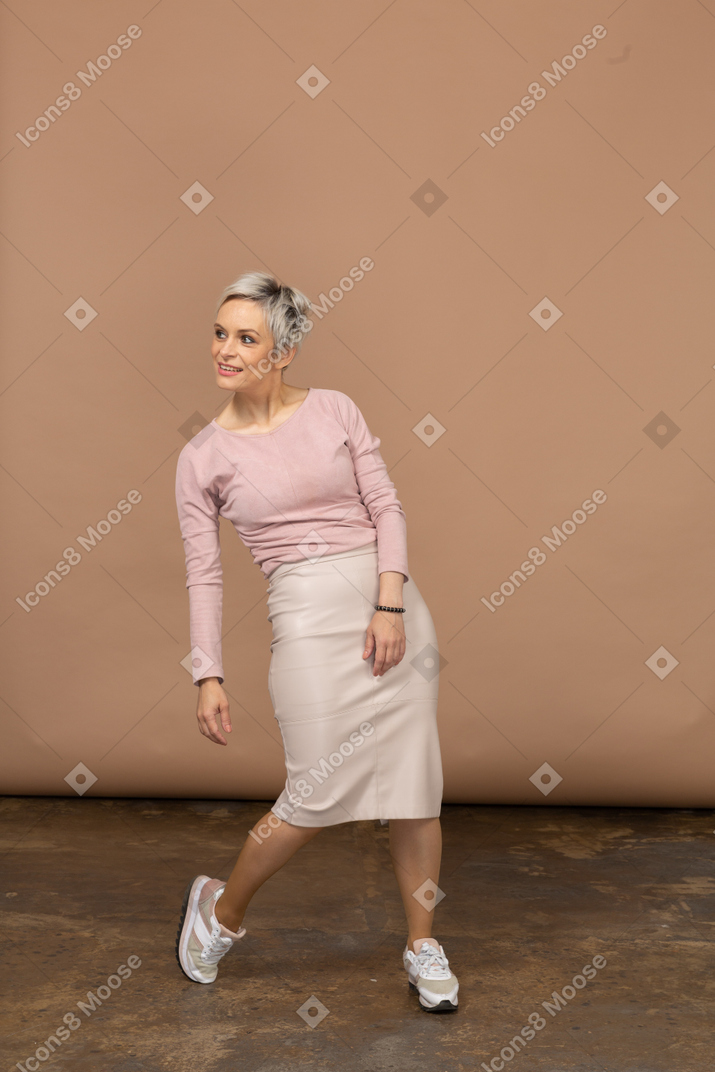 Vista frontal de una mujer feliz en ropa casual inclinándose hacia atrás