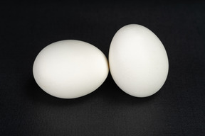 黒の背景に2つの卵をクローズアップ