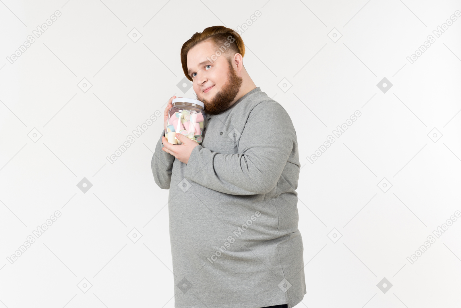 Dreamy big bearded man holding jar of marshmallows