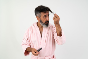 Uomo maturo guardando i suoi capelli