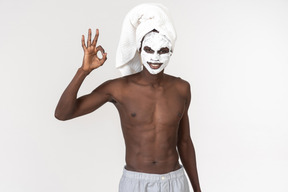 Man in face mask showing an ok gesture